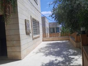 a building with a sidewalk next to a fence at Flower 2 in Jerash