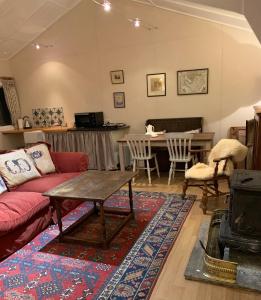 a living room with a couch and a table at One bedroom lodge in the countryside in Congleton