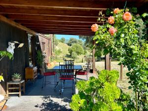 a patio with a table and chairs and flowers at Preciosa Casa de Madera, Andalucía in Prado del Rey