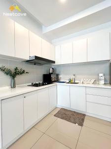 a white kitchen with white cabinets at Novo 8 Residences & Suites AQUA Pool by Nestcove in Melaka