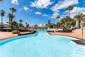 uma piscina num resort com palmeiras em Apartamento Rockbeach em Costa Teguise