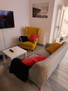 a living room with a couch and a chair at Ferienhaus 6969 in Tossens in Tossens