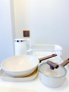 two pans sitting on top of a counter with a wooden spatula at Astra Sky River Chang Klan Chaing Mai in Chiang Mai