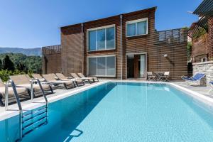 a swimming pool with chairs and a house at Residence Lenno in Lenno