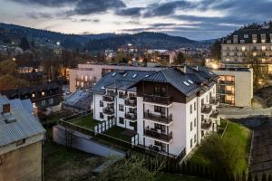 an apartment building in a city at dusk at Centrum Cicha, Sun & Snow in Krynica Zdrój