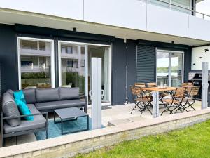 a patio with a couch and a table and chairs at Lieblingshafen in Heiligenhafen