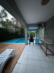 a patio with a ping pong table and a pool at Villaras Garden özel havuzlu eşyalı in Altınkum