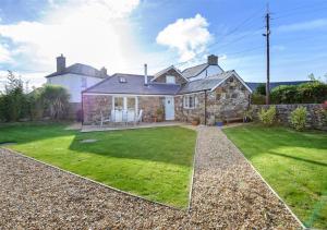 a stone house with a lawn in front of it at Jennys Cottage in Abersoch