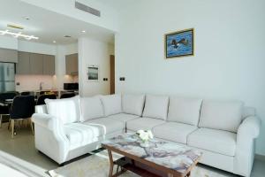 uma sala de estar com um sofá branco e uma mesa de centro em Brown Stone Holiday Homes Act em Dubai