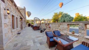 a patio with chairs and tables on a stone wall at Premium Cappadocia House in Goreme