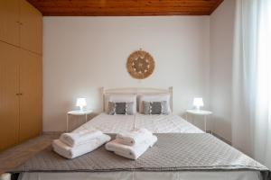 a bedroom with a white bed with towels on it at Gaia Limnos Apartments 1 & 2 in Kornós
