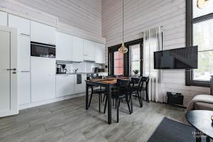 a kitchen and dining room with a table and chairs at Holiday in Lapland - Sointuilevi A59 in Levi