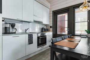a kitchen with white appliances and a wooden table at Holiday in Lapland - Sointuilevi A59 in Levi