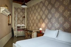 a bedroom with a bed and a table and a desk at B&B Lorenzo&Lorenzo Vol.2 in Florence