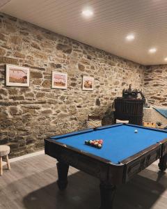 a pool table in a room with a stone wall at Casa do Cruzeiro Quinta do Couto in Armamar
