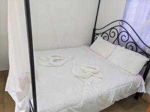 Una cama con sábanas blancas y almohadas blancas. en STC.SAFARI LODGE en Oldeani