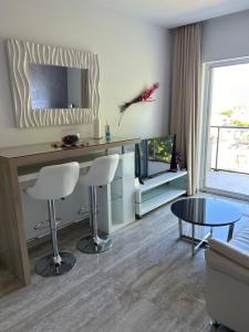 een woonkamer met een tafel en een televisie bij Marlin Apartments in Dubrovnik