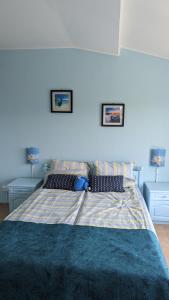 een blauwe slaapkamer met een bed met 2 nachtkastjes bij Guest House Chalakov in Sinemorets