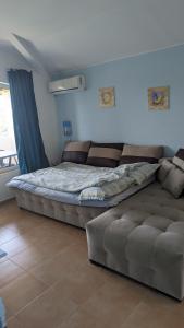 a large bed and a couch in a room at Guest House Chalakov in Sinemorets
