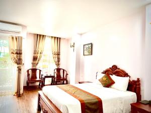 1 dormitorio con 1 cama, 2 sillas y ventana en TRƯỜNG GIANG HOTEL Móng Cái en Móng Cái
