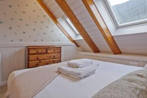 a attic bedroom with a bed and a window at Luderna - Dúplex Cap de Aran D3 in Baqueira-Beret