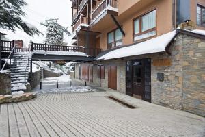 a building with a walkway next to a building with snow at Luderna - Dúplex Cap de Aran D3 in Baqueira-Beret