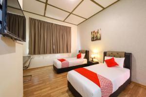 une chambre avec deux lits et une télévision à écran plat dans l'établissement Ivory Boutique Hotel, à Rawang