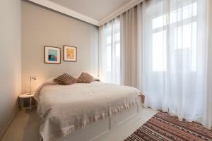 a white bedroom with a bed and a window at Marias River Apartment in Porto