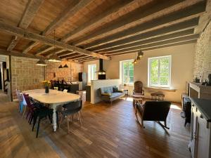 a living room with a table and a dining room at La Forge 8 Personnes in Bèze