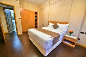 1 dormitorio con 1 cama blanca grande y armario en Speke Apartments Wampewo en Kampala