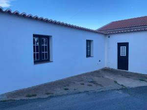 a white house with two windows and a roof at Vila Dias in Mértola