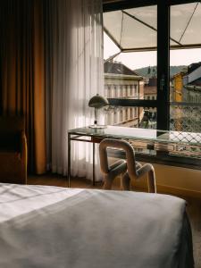 Hotel Josef في براغ: غرفة نوم بسرير ومكتب ونافذة
