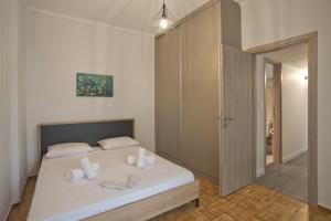 1 dormitorio con 1 cama con sábanas blancas y espejo en Like Home, en Atenas