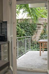 una puerta abierta a un balcón con mesa en Like Home, en Atenas