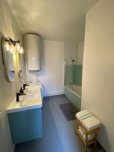 a bathroom with two sinks and a shower and a toilet at Appartement T4 et Parking à 3km du Futuroscope in Jaunay-Marigny +7 photos