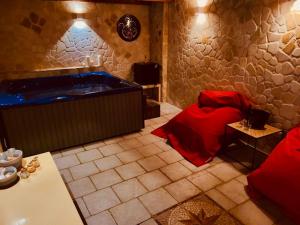 萊切的住宿－Il Giardino Di Flora - Piscina & Jacuzzi，带浴缸的浴室和红色的床。