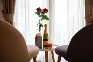 eine Flasche Champagner und eine Vase mit Blumen auf dem Tisch in der Unterkunft Sunset & Sunrise Villas in Stanisici-Two Villas With Common Pool in Budva
