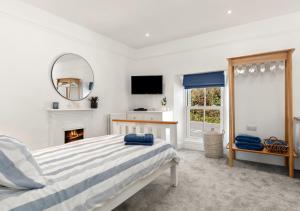 a bedroom with a bed and a mirror and a fireplace at Enfield House in Saundersfoot
