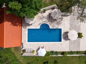 una vista aérea de una piscina con sillas y sombrillas en Sunset & Sunrise Villas in Stanisici-Two Villas With Common Pool, en Budva