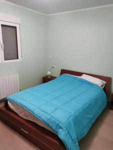 a bedroom with a blue bed with a window at Casa de Rosa in Boquilla