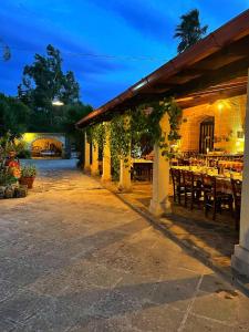 um restaurante ao ar livre com mesas e cadeiras à noite em Masseria Scianne em Sant'Isidoro