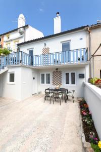 a patio with a table and chairs in front of a house at MIA Family Apartments Punat in Punat