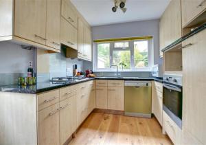 a large kitchen with wooden cabinets and a window at Middleton View in Ilkley