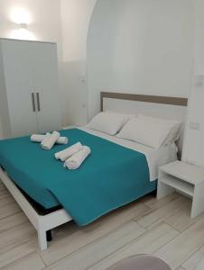 1 dormitorio con 1 cama con 2 toallas en B&B SOLE en Torre San Giovanni Ugento