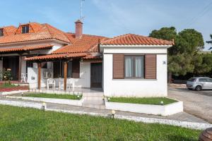 a white house with a red roof at Gaia Limnos Apartments 1 & 2 in Kornós