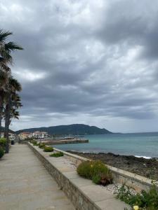ein Gehweg neben dem Meer mit einem bewölkten Himmel in der Unterkunft Le tre stelle in Castellabate