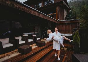 a bride and groom standing on the deck of a house at Hotel Tri Studničky - Adult friendly in Belá