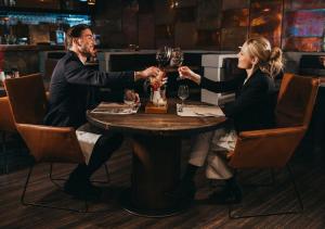 two people sitting at a table with glasses of wine at Hotel Tri Studničky - Adult friendly in Belá