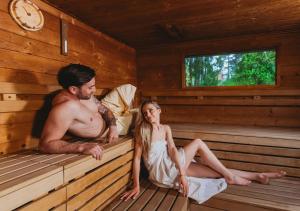 a man and woman sitting in a sauna at Hotel Tri Studničky - Adult friendly in Belá +47 photos