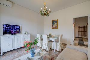 sala de estar con mesa y TV en Casa Milly - Happy Rentals, en Desenzano del Garda